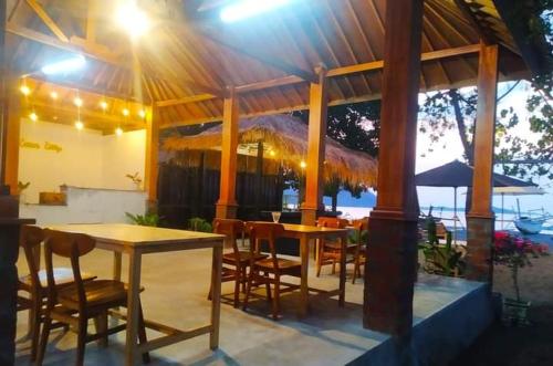 a patio with tables and chairs under a pavilion at Cemare Cottage in Lembar