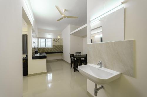 a bathroom with a sink and a ceiling fan at Fortune Inn in Erode