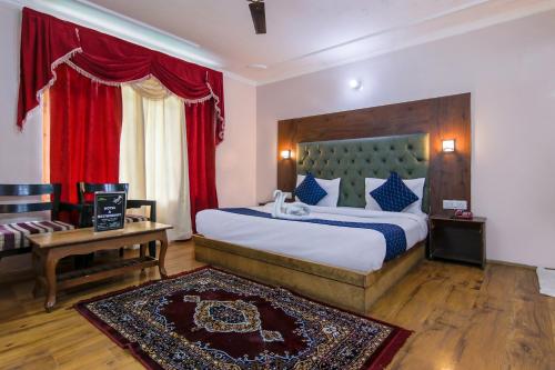 a bedroom with a large bed with a red curtain at FabHotel The Moon in Manāli