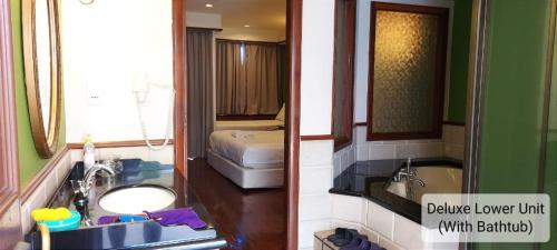 a bathroom with a sink and a bathroom with a bed at Alpine LXPD Water Chalet in Port Dickson
