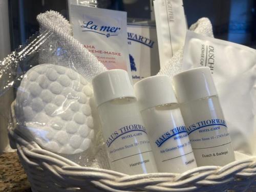 a basket with a bunch of moisturizers and a golf ball at Haus Thorwarth - Hotel garni in Cuxhaven