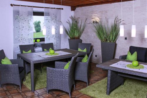a dining room with tables and chairs and plants at Landhaus Am Forst in Bad Alexandersbad