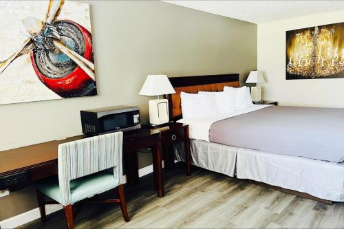 a hotel room with a bed and a desk with a computer at Western Motel, Thomasville in Thomasville