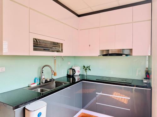 a kitchen with white cabinets and a sink at NalSol House in Hanoi