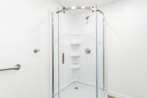 a shower with a glass door in a bathroom at Luxurious 4 BR Townhouse in New York