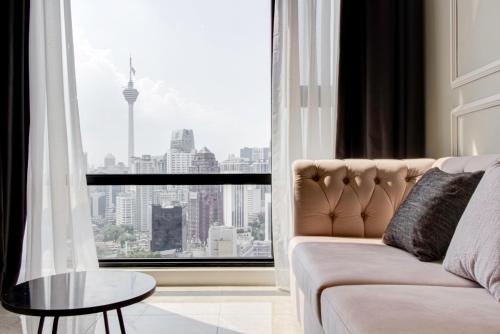 a living room with a couch and a large window at Axon Residence at Pavilion KLCC KL Tower view by KIMIRO in Kuala Lumpur