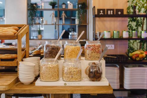 a table with four jars of granola and bread at ibis Lyon Est Meyzieu in Meyzieu