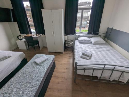 a bedroom with two beds and a window at Hotel-Chao NL 24 hours open in Utrecht