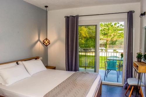 une chambre avec un lit et une porte coulissante en verre dans l'établissement Ktima Holiday House, à Skiathos Chora