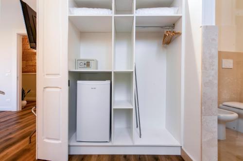 a closet with white cabinets and a refrigerator at Vittoria Luxury House in Lecce