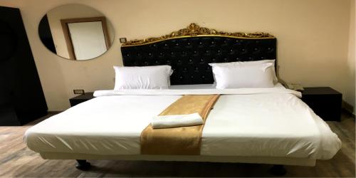 a bedroom with a large bed and a mirror at Ellyxville Hotel in Lekki