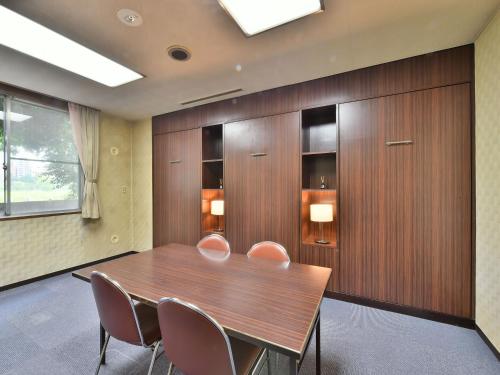 a conference room with a wooden table and chairs at Hotel Kangetsuso in Tokyo