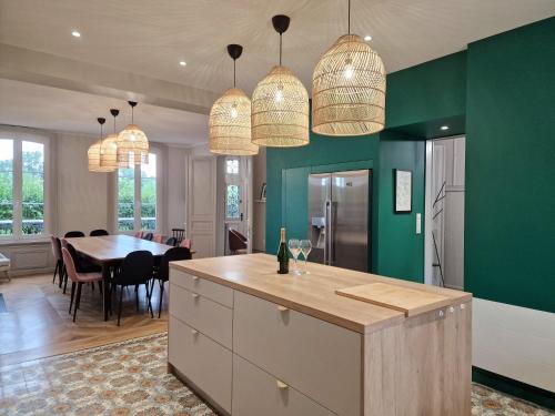 - une cuisine et une salle à manger avec des murs verts et une table dans l'établissement Le Nid du Chardonnay, à Vanault-le-Châtel