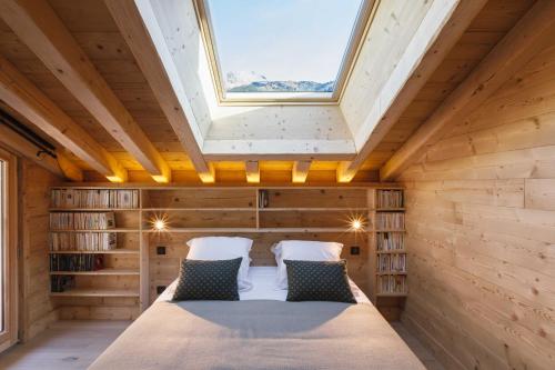 a bedroom in a wooden house with a skylight at Bio Corti Spa 12 personnes in Champagny-en-Vanoise