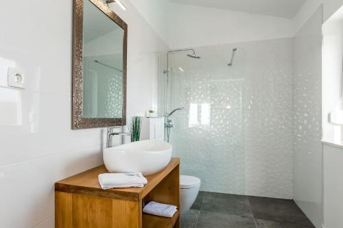 een witte badkamer met een wastafel en een spiegel bij Villa Sky in Primošten