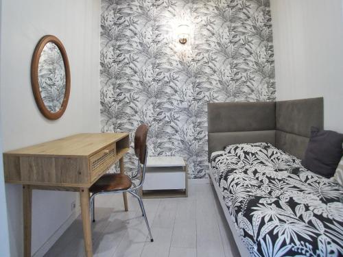 um quarto com uma secretária, uma cama e um espelho em Appartement Ardoines Shelter em Vitry-sur-Seine