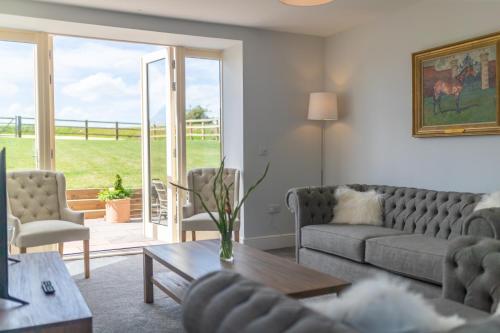 a living room with a couch and a table at Butterwick - Barn Conversion with a hot tub on a Country Estate in Holbeck