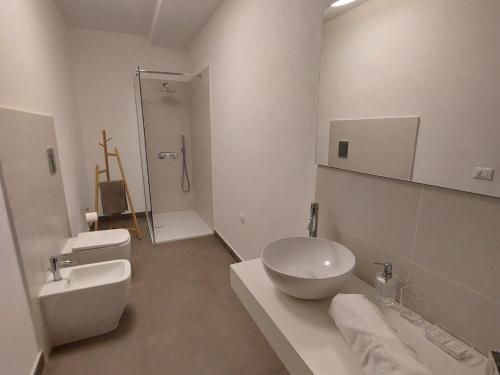 een witte badkamer met een wastafel en een toilet bij Mondello Relax in Mondello