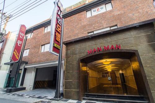 a man man entrance to a building with a sign at Shine Motel in Busan