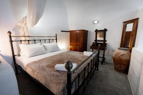 a bedroom with a large bed and a desk at Lotza Studios in Oia
