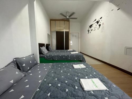 a bedroom with two beds and a ceiling fan at Joyful homestay Miri in Miri