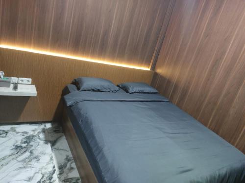 a bed in a room with a wooden wall at V Quin in Semarang