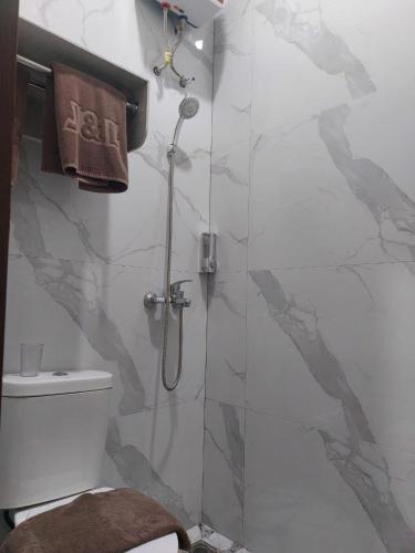 a bathroom with a shower with a toilet and a glass door at V Quin in Semarang
