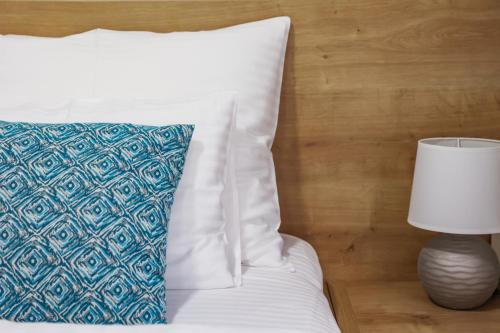 a bed with a pillow and a lamp next to it at Grand Park rooms & apartments in Čačak