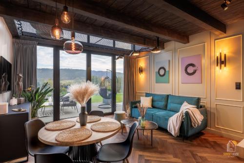 a living room with a blue couch and a table at Sunset House & Spa in Ustrzyki Dolne