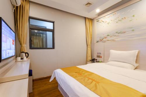 a bedroom with a bed and a flat screen tv at Qi Cheng Hotel - Shenzhen North Railway Station in Shenzhen