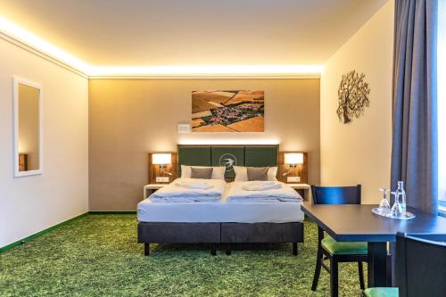ein Hotelzimmer mit einem Bett und einem Tisch in der Unterkunft Pension Schwalbennest in Bösleben-Wüllersleben