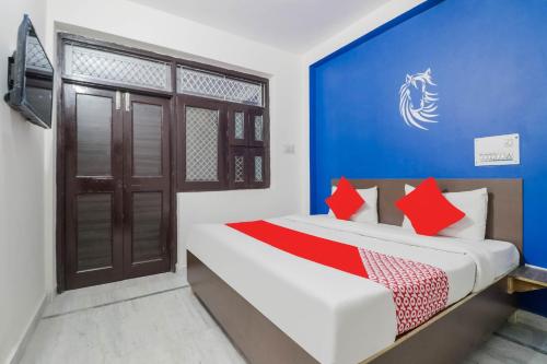 a bedroom with a blue wall and a bed with red pillows at OYO Flagship R.S. RESIDENCY in New Delhi