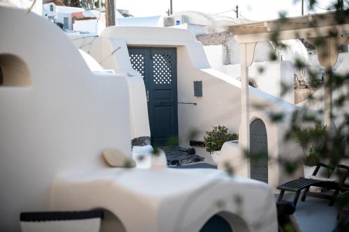 a white house with a green door and stairs at Lotza Studios in Oia