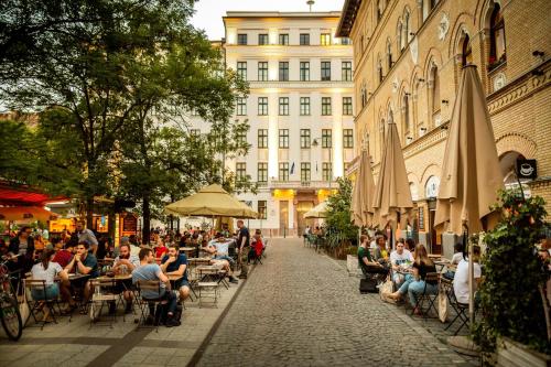 a group of people sitting at tables on a street at Palace Quarter 1 Peaceful Modern Central Top Floor Apartment in Budapest