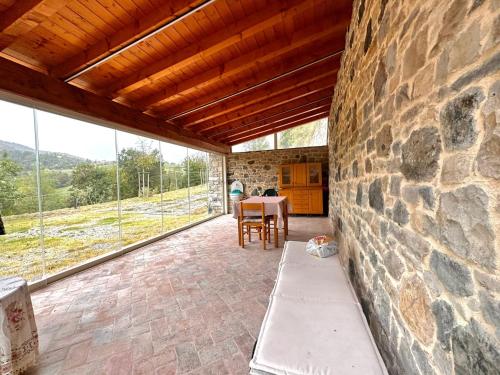 a patio with a stone wall and a table and chairs at La casa della nonna in Serramazzoni