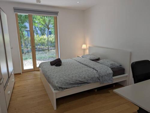 1 dormitorio con cama y ventana grande en Stylish 2BR Apartment w/ Garage+Garden in Howald/Hesperange, en Hesperange