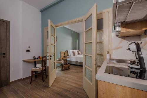 a kitchen with a sink and a room with a bed at Cathedral Suites in Heraklio