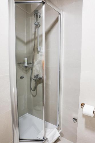 a shower with a glass door in a bathroom at Grand Park rooms & apartments in Čačak