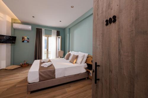 Un dormitorio con una cama y una puerta de madera. en Cathedral Suites, en Heraclión