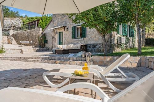 a table with two chairs and an umbrella at Hacienda Sylvia - secluded 4-bedroom villa with 45sqm heated pool in Studenci