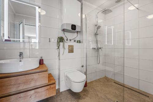 a bathroom with a toilet and a sink and a shower at Hacienda Sylvia - secluded 4-bedroom villa with 45sqm heated pool in Studenci