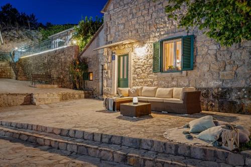 a stone house with a couch and a table at Hacienda Sylvia - secluded 4-bedroom villa with 45sqm heated pool in Studenci