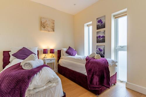 的住宿－Modern & Classy 2 bedroom flat, Free Parking，卧室内的两张床,配有紫色毯子