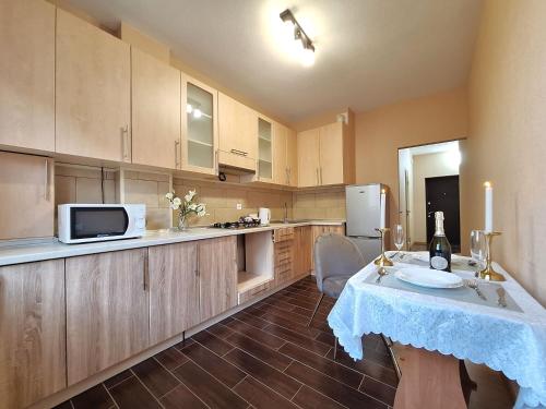 una cucina con tavolo e forno a microonde di Велике ліжечко на Садовому. Мережа Alex Apartments. Цілодобове безконтактне заселення a Poltava