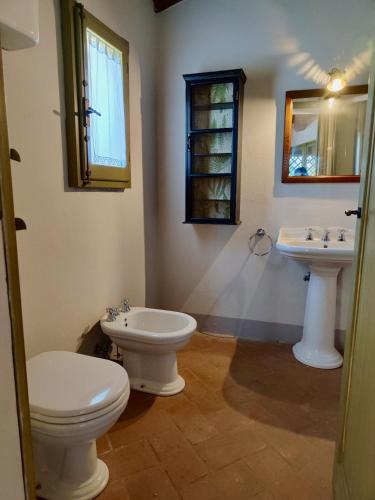 a bathroom with two sinks and a toilet at The Monastery - St Antimo in Monterchi