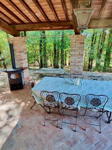 a patio with a table and chairs and a stove at The Monastery - St Antimo in Monterchi