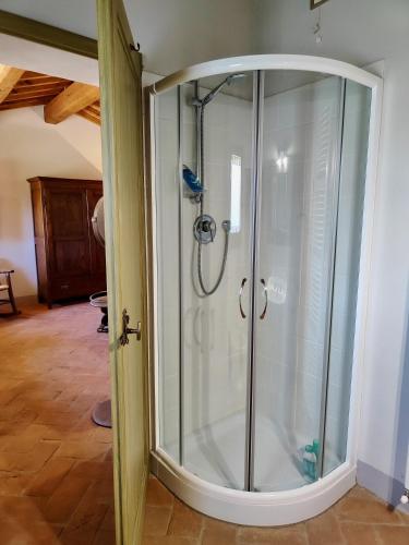 a shower with a glass door in a room at The Monastery - St Antimo in Monterchi