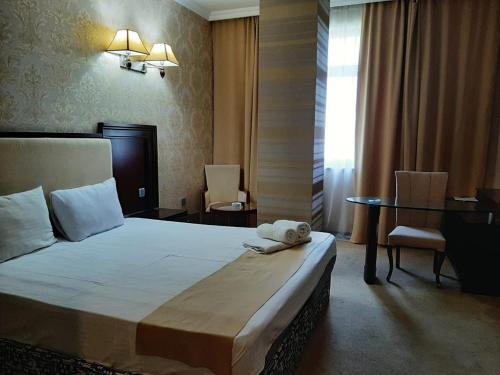 a hotel room with a bed and a table and chairs at Emerald Gold Hotel in Baku