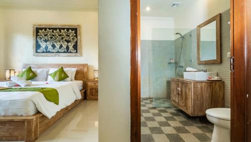 een slaapkamer met een bed, een douche en een toilet bij Jegeg Mas in Ubud