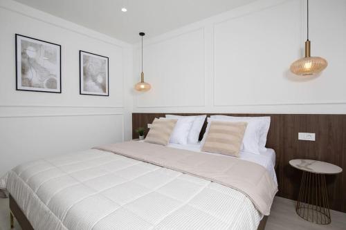 een slaapkamer met een groot bed met witte lakens en kussens bij Villa Artis by IstriaLux in Loborika